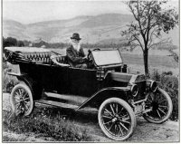 Driving his car on the farm where je drove oxen as a boy